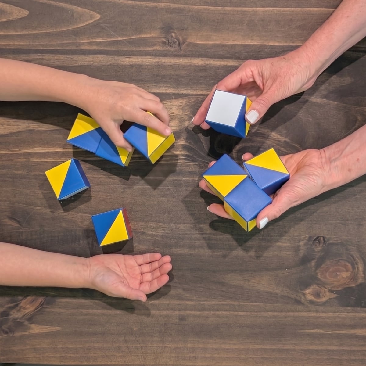 A child and clinician building blue and yellow blocks during a block-design cognitive assessment