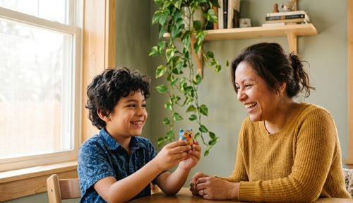 Child beaming with pride while showing a parent something they made at home